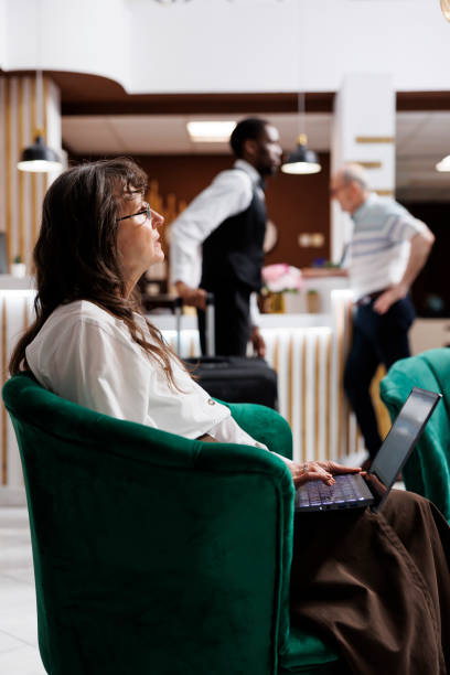 istock Elderly woman using laptop in hotel 1691937234