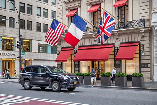 Fifth Avenue, Manhattan, New York, USA - August 8th 2023: Shop with American, French and British flag on the facade
