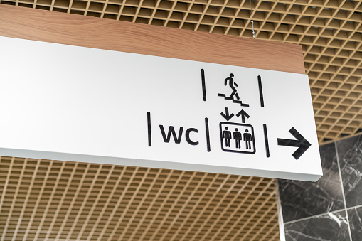 An information sign indicates directions to the toilet and stairs in a shopping center or other public place.