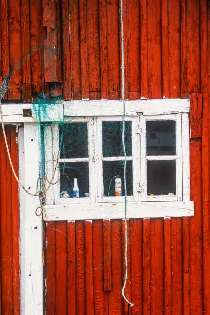 Old red wooden cottage with fishnet