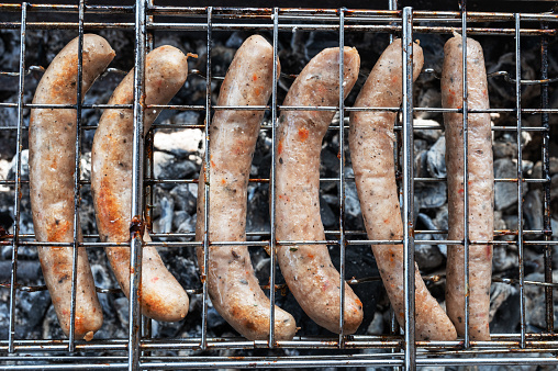 Grilling sausages on the steel grid