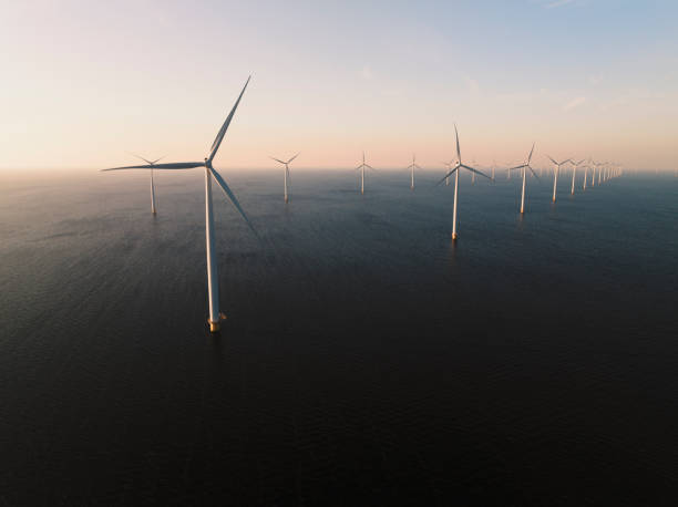 Wind turbines in an offshore wind park producing electricity during sunset