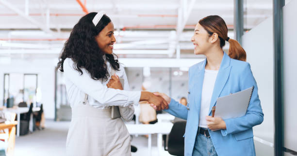 istock Business women, handshake and welcome, introduction and hello to new intern while walking in office. Happy, excited and diversity workers shaking hands for support, teamwork or onboarding partnership 1691964376