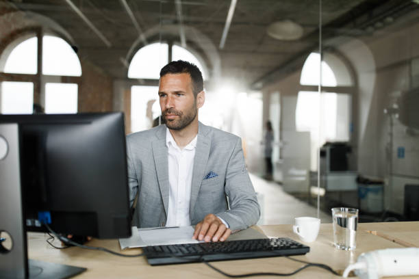 istock Businessman working on desktop PC at corporate office. 1691973761