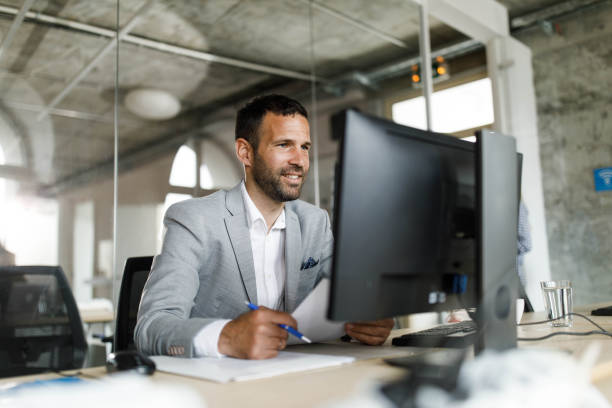istock Happy entrepreneur working on paperwork and desktop PC in the office. 1691974231