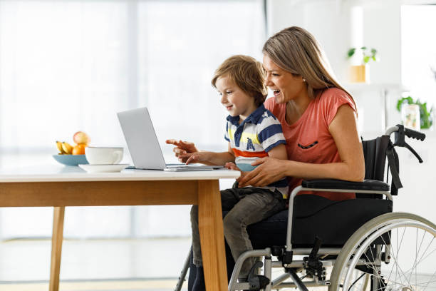 istock Happy disabled mother and her small son using computer at home. 1691981241