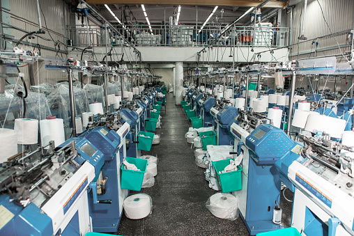 Interior of garment factory shop. Textile workshop with sewing machines, industry concept