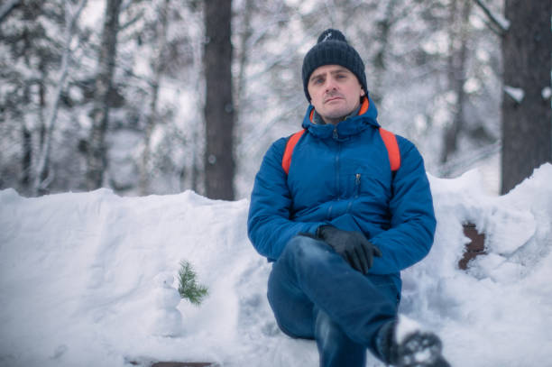 istock Man in winter jacket walking in snowy winter forest 1691988545