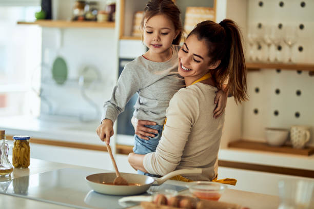 istock A mom holding her daughter, making breakfast together, at home. 1691989191