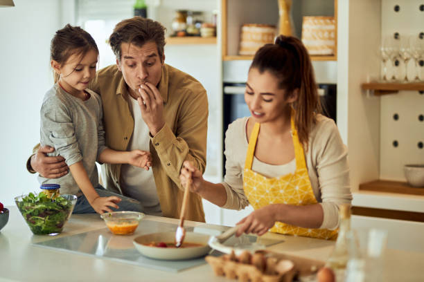 istock Father and daughter are supportive while mom is cooking lunch. 1691991554
