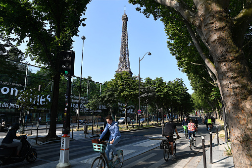 Paris, France-06 28 2023: Group of cyclist on a cycle path in Paris, France with a view of the Eiffel tower in the background.