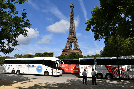 Paris, France-07 26 2023: Coaches parked in a street in front  of the Eiffel tower in Paris, France.