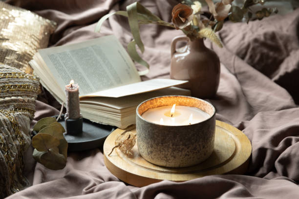 istock Home still life with a candle and a book in bed. 1692023105
