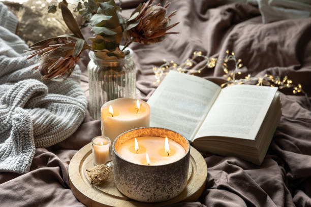 istock Home still life with a candle and a book in bed. 1692023114