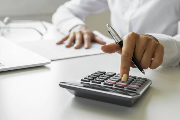 istock Female hand using calculator and laptop in office 1692024742