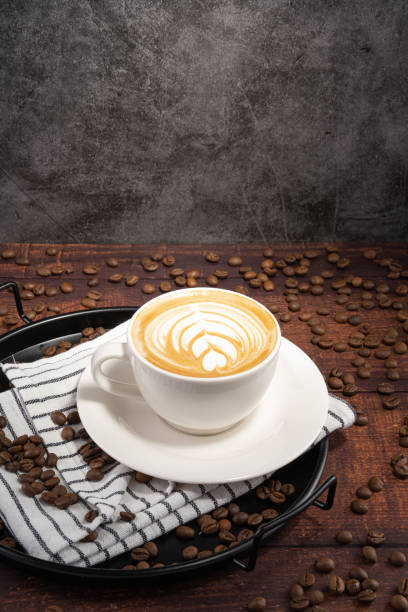 Caffe latte and coffee beans in white mug - production studio shot