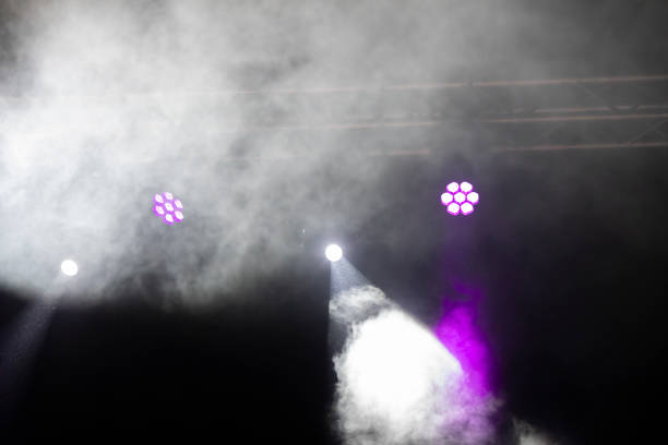 istock Stage lighting. Spotlights with colored lights on a stage. Artificial lighting. Black background and blur. 1692065046