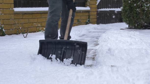 istock Man Clearing Backyard Pavement of Snow with Snowshovel 1692067374