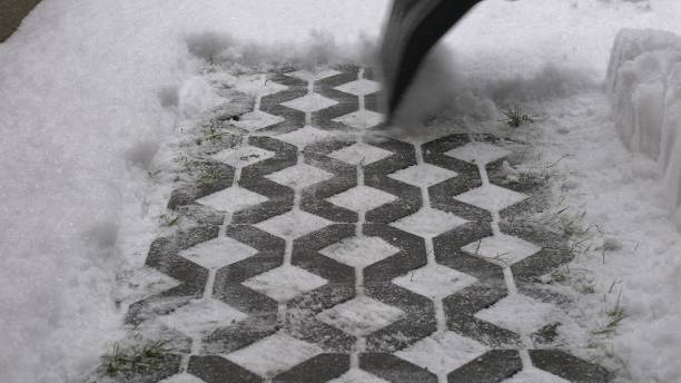 istock Man Clearing Backyard Pavement of Snow with Snowshovel 1692067390