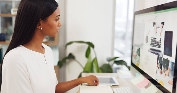 istock Fashion, design and computer with a woman designer writing creative notes in her notebook at work. Internet, technology and website with a young female employee working at her desk in a modern office 1692069110