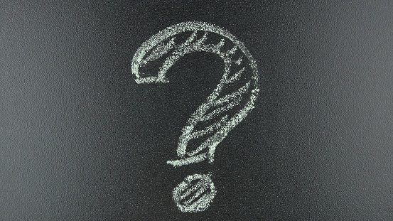 Drawing Question Mark with Chalk on a Blackboard