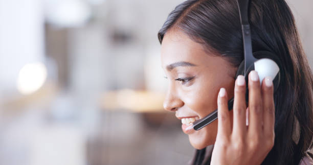 istock Call center agent helping client in a phone call giving great customer service. Customer support employee consulting clients online using headset. Professional friendly woman working at her desk 1692080822