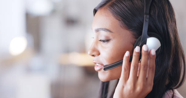 istock Call center agent helping client in a phone call giving great customer service. Customer support employee consulting clients online using headset. Professional friendly woman working at her desk 1692080824