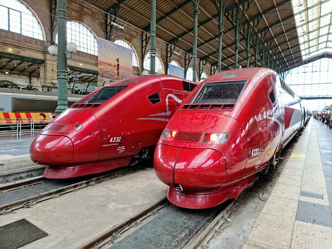 Paris-Nord is one of the seven large mainline railway station termini in Paris, France. The image shows the station with a Thalys high speed train and several people.