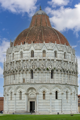 Pisa, Italy - May 13, 2019: View of Pisa Baptistery of St. John, Duomo Square of Pisa (Piazza del Duomo). It is a Roman Catholic ecclesiastical building