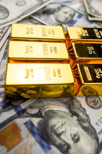 istock gold bars over dollar money bills, investment saving concept 1692087351
