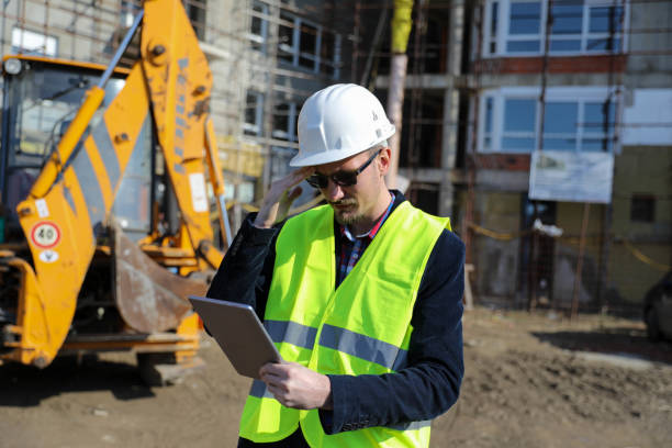 istock Male architect using digital tablet at construction site, he wears a protective vest and helmet 1692091267