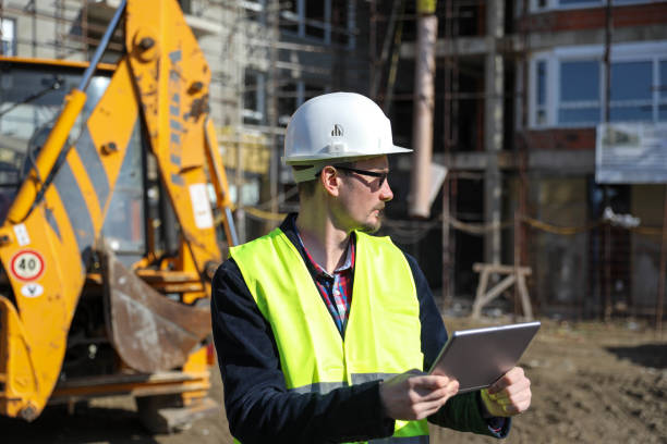 istock Male architect using digital tablet at construction site, he wears a protective vest and helmet 1692091288
