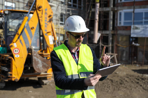 istock Male architect using digital tablet at construction site, he wears a protective vest and helmet 1692091299