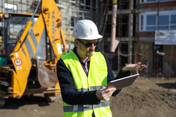 istock Male architect using digital tablet at construction site, he wears a protective vest and helmet 1692091837