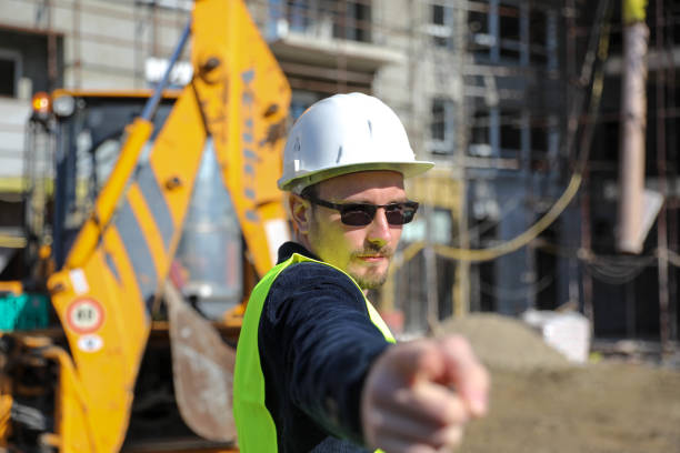 Professional technician engineer with protective helmet works on maintenance of construction equipment in industrial factory, inspection man who has production occupation of manufacturing technology