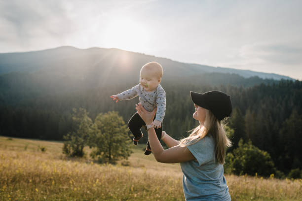 istock The mother throws up his happy son into the sky with his hands. Walking in nature on an autumn day. Mom and baby child playing in the mountains. Concept of family spending time together on vacation. 1692113708
