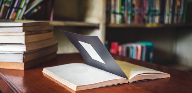 istock Vintage style.An open book or textbook vintage style in the library with light from the window on the reading table and the corridor of the bookshelves in a Stack of books background.Education learning concept 1692117767