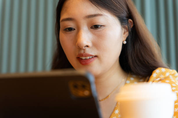 istock Woman sitting at a coffee shop using digital tablet 1692124728