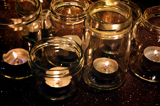 High angle view of burning candles in glass jars on background. For holiday and lifestyle greeting card or background - Holiday, Christmas and new year concept