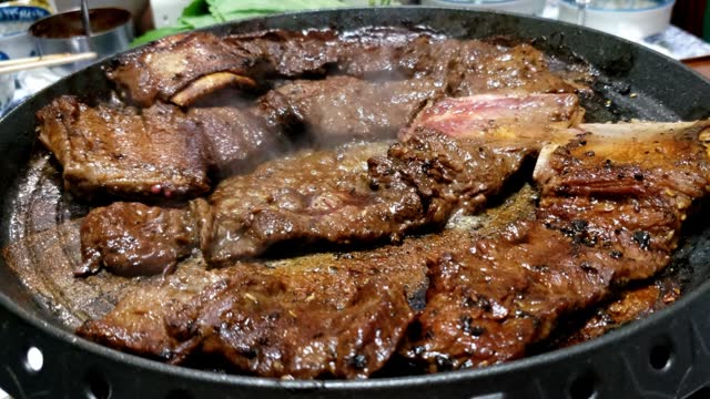 Korean Barbequed Beef Short Ribs (Kalbi or Galbi) sizzling on a hot plate
