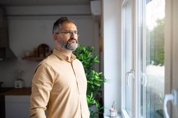 istock Pensive Caucasian mid-adult man, looking thorough window 1692134121
