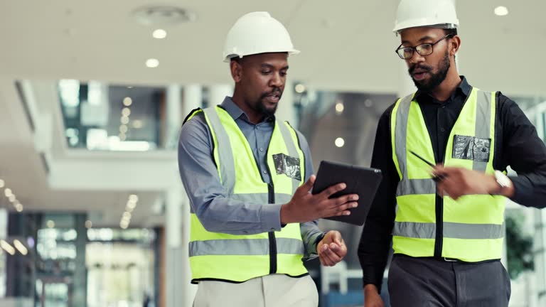 Teamwork, tablet and engineer people talking about construction, project management and renovation. Planning, maintenance app and internet with black men or staff walking in building with technology