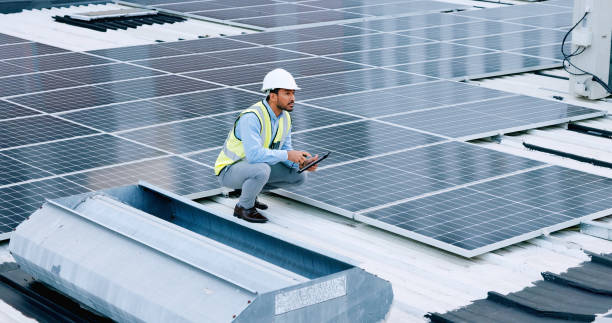 istock Engineer or contractor measuring solar panels on a roof of a building. Engineering technician or electrician installing alternative clean energy equipment and holding a tablet to record measurements 1692149879