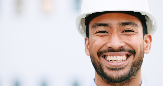 Face of a contractor and maintenance manager smiling and laughing at a construction site with copy space. Portrait of a happy engineer with a hardhat overseeing a successful project development