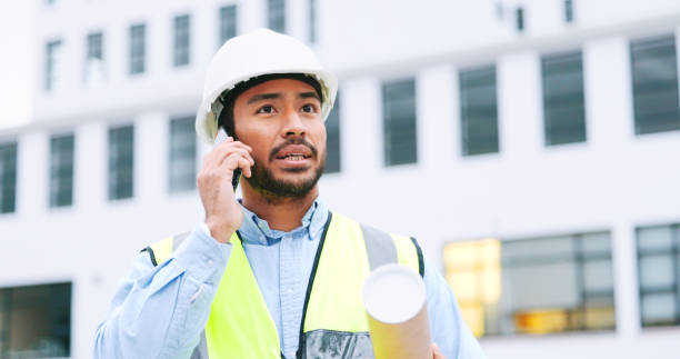 istock Civil engineer on a phone call while at a construction site discussing a strategy and plan to work on. Close up portrait of confident architect talking with building in the background and copy space 1692149914