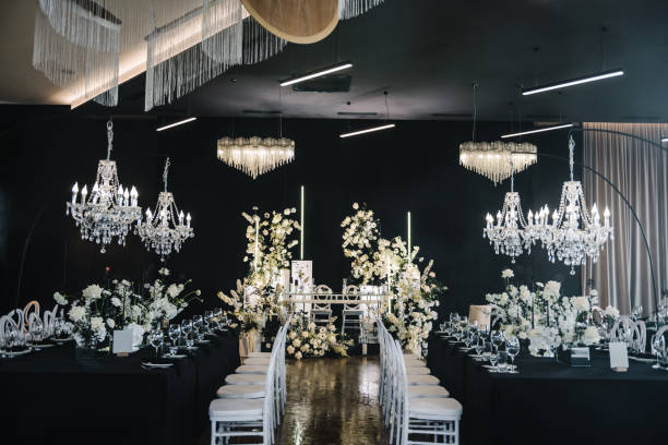 istock Luxury wedding reception. Table setting, setup. Banquet decoration composition flowers, candles in hall restaurant. Table covered black tablecloth. Trendy decor large chandelier for a birthday party. 1692151135