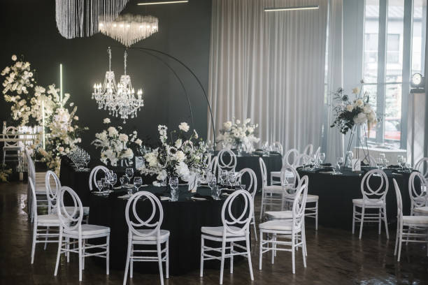 istock Table setting, setup. Trendy decor large chandelier for a birthday party. Luxury wedding reception. Banquet decoration composition flowers, candles in hall restaurant. Table covered black tablecloth. 1692151264