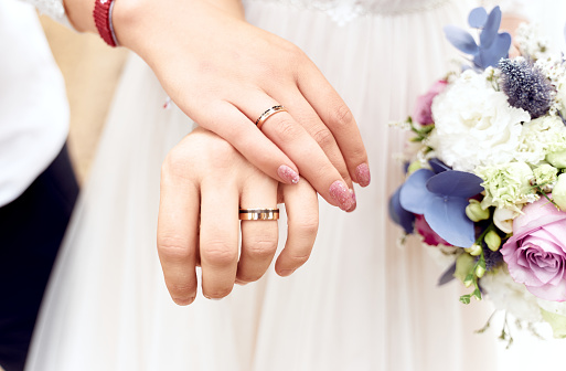 Closeup of hands of bridal couple with wedding rings