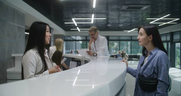 istock Asian female administrator talks with patient on reception 1692168028