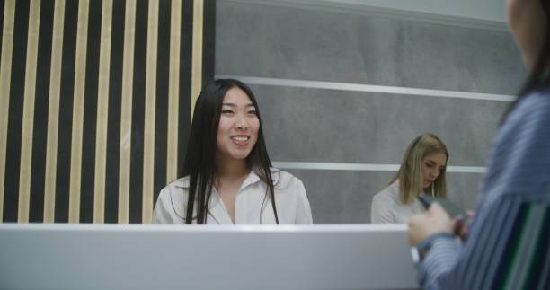 istock Asian female administrator talks with patient on reception 1692168610